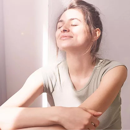 smiling woman sitting in sunlight indoors