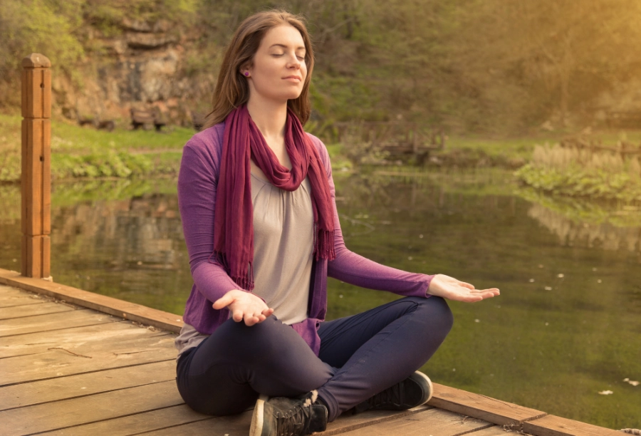 woman meditating on dock