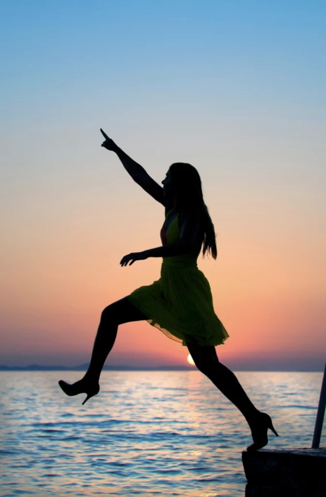 woman pointing and stepping off pier