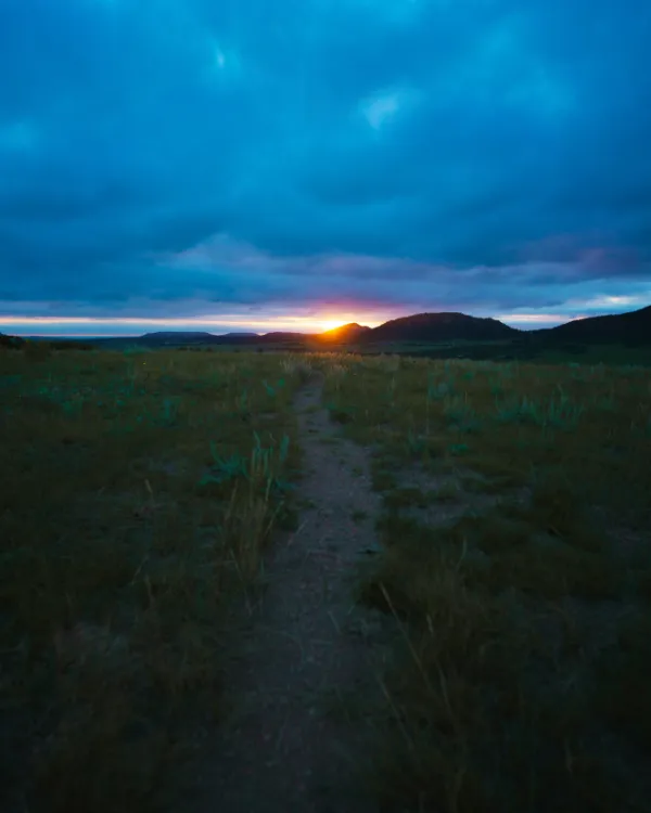 mountain path with sun in distance