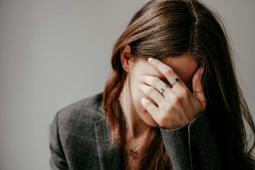 woman covering face with hand